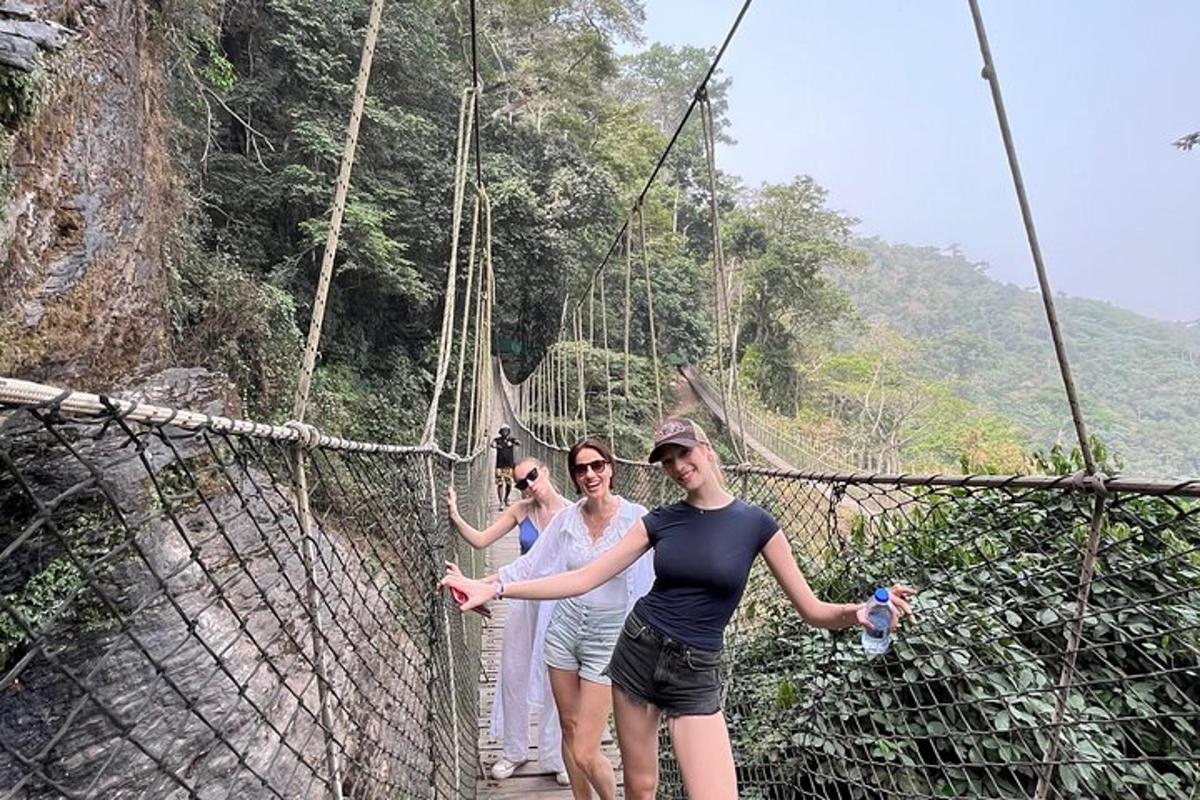 tre persone su un ponte sospeso in montagna