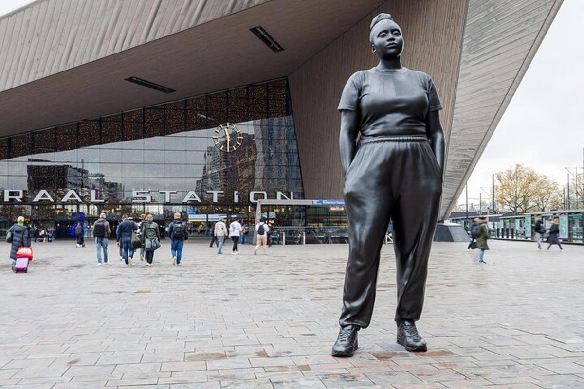 una statua di una donna in piedi davanti a un edificio