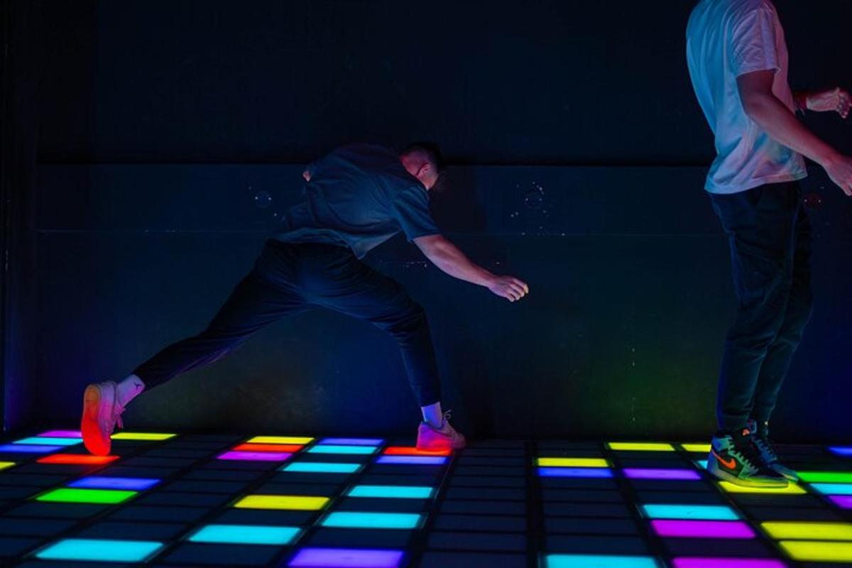 a man dancing on a dance floor with colored lights