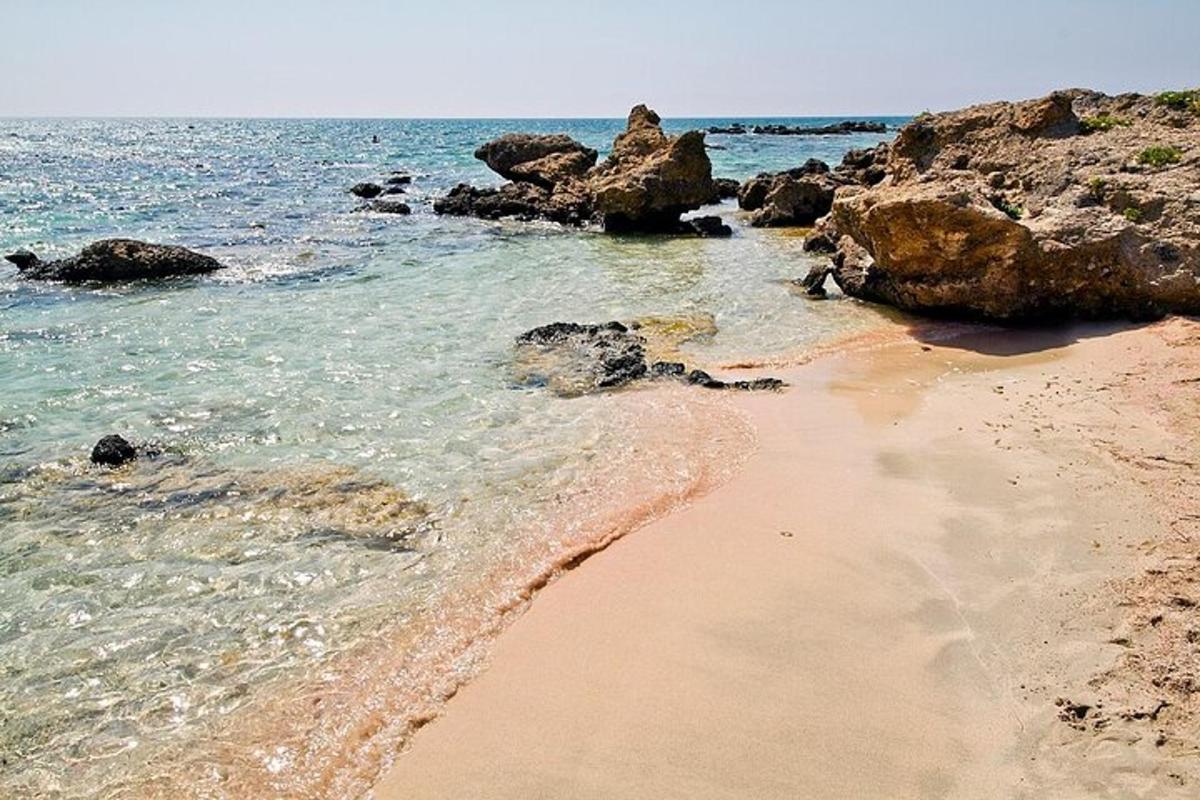una spiaggia sabbiosa con rocce e l'oceano