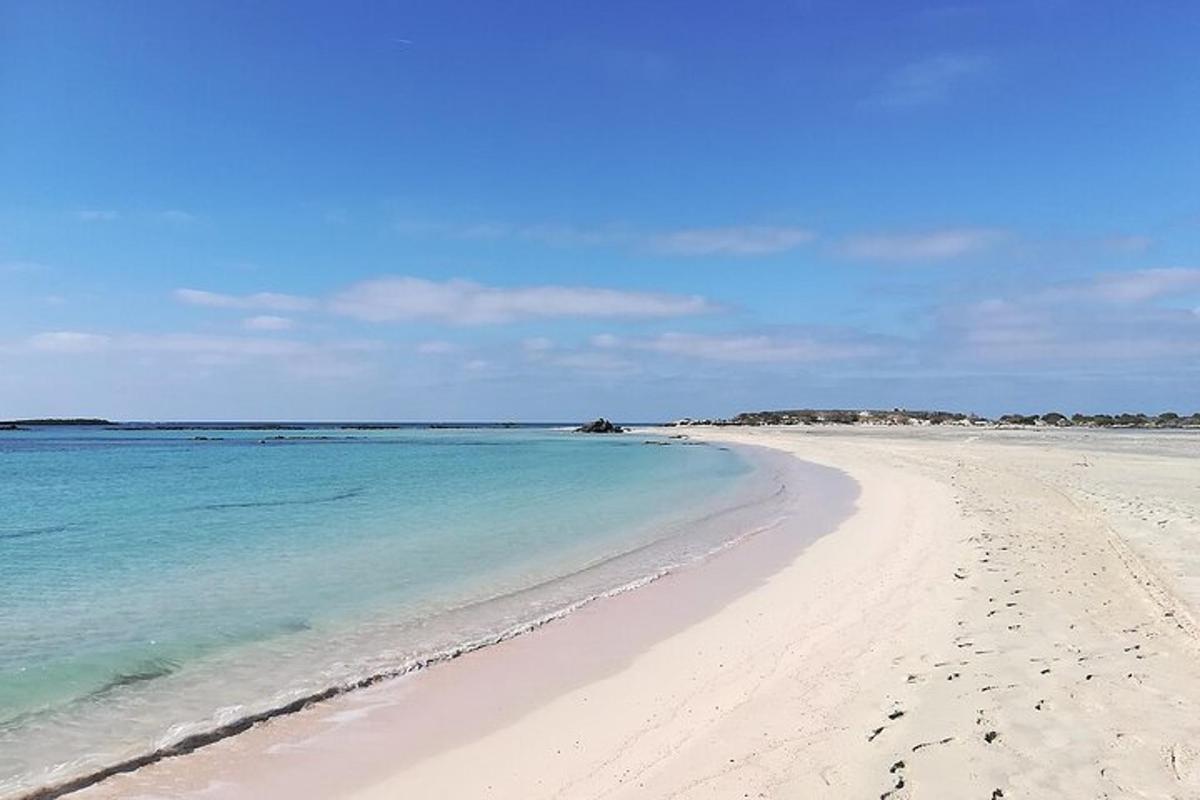 una spiaggia con acqua blu e impronte nella sabbia
