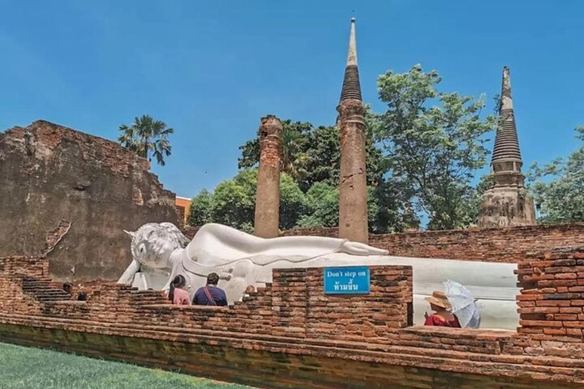 Un grupo de personas de pie frente a una estatua