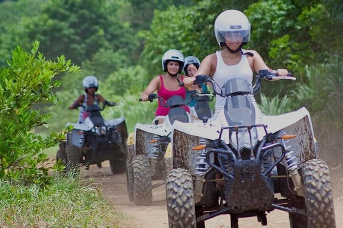 un gruppo di persone che guidano quad su una strada sterrata