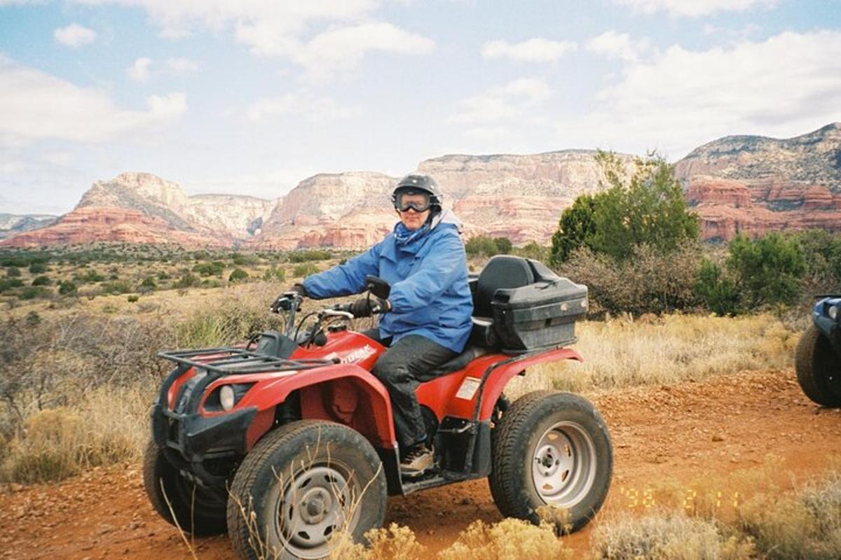 a man riding on a four wheeler on a dirt road
