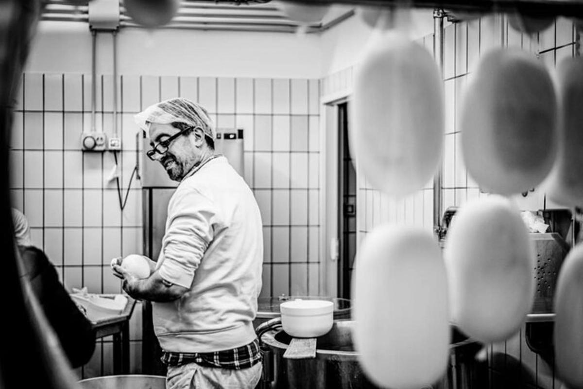 Un hombre de pie en una cocina preparando comida.