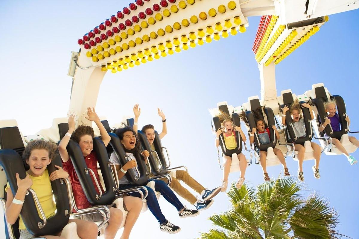a group of people riding on a roller coaster at a theme park