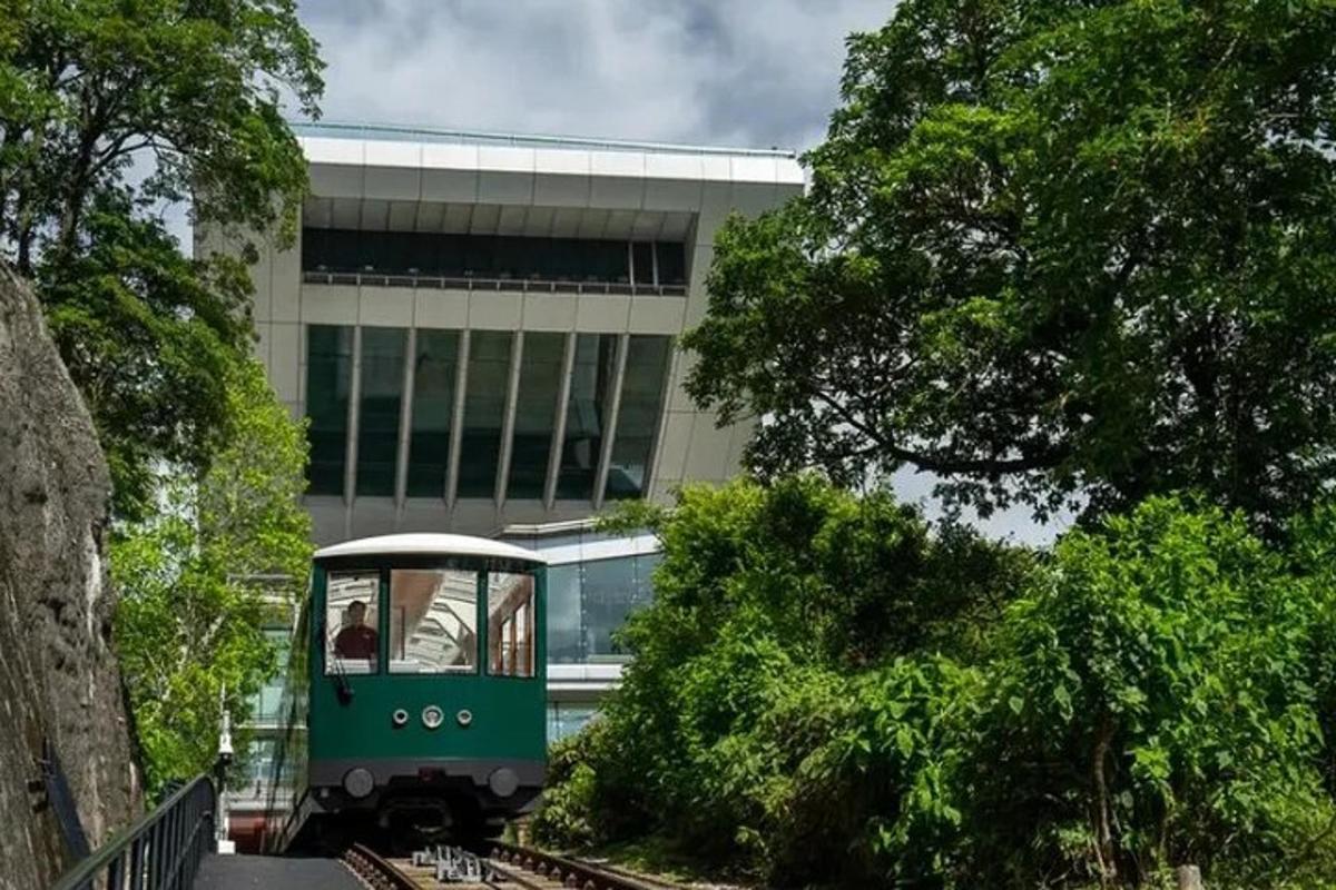 un tren verde pe șine în fața unei clădiri
