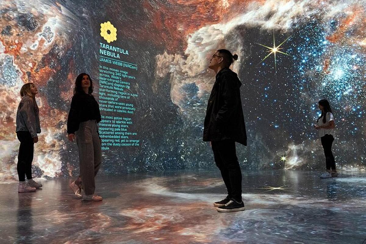 a group of people standing in front of a universe