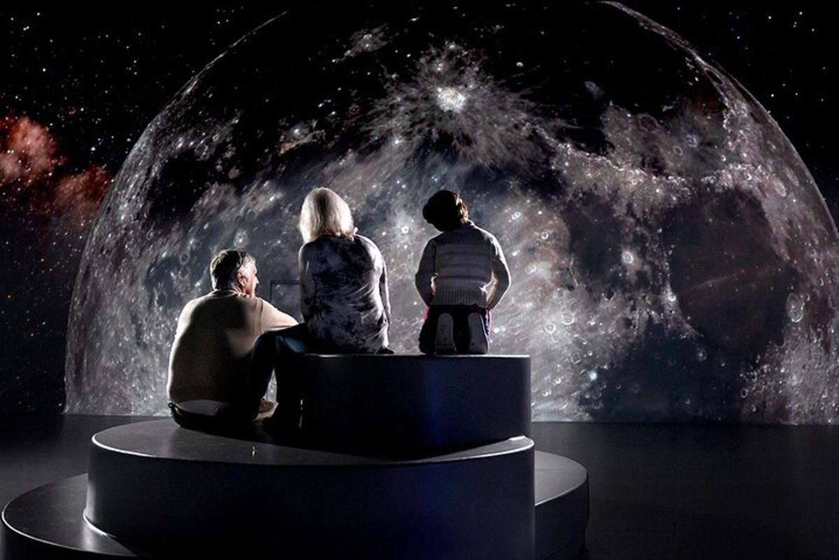 a group of three people sitting in front of a universe