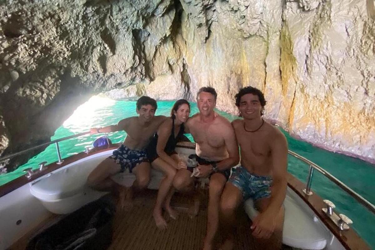 un gruppo di persone sedute su una barca in una grotta