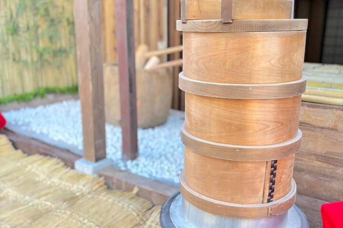 a stack of wooden barrels sitting next to a fence