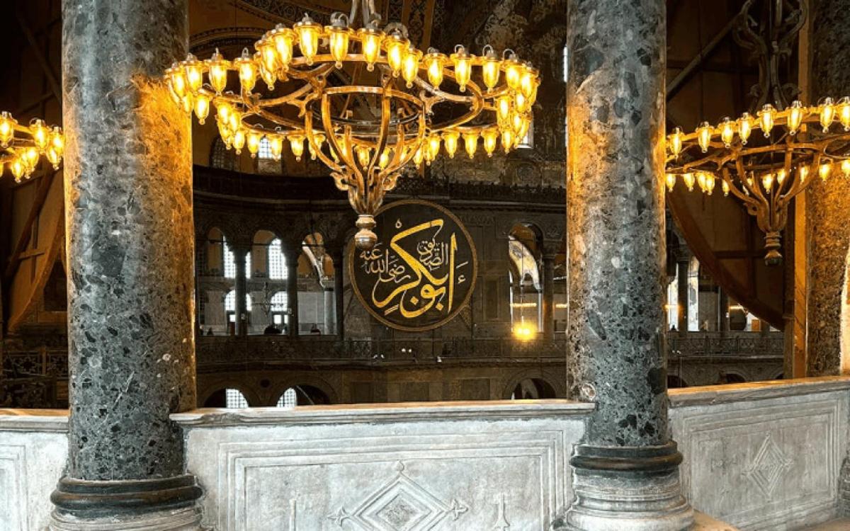 o cameră mare cu candelabre și un ceas într-o clădire