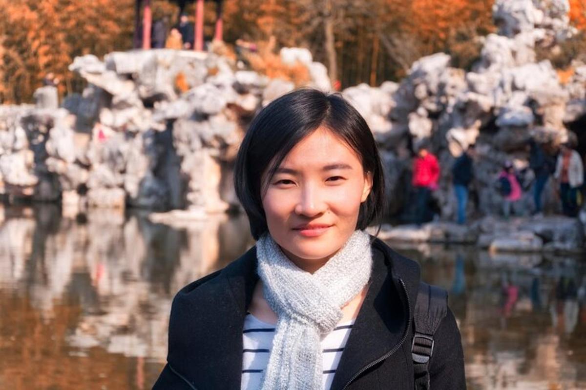 一位女士站在喷泉前