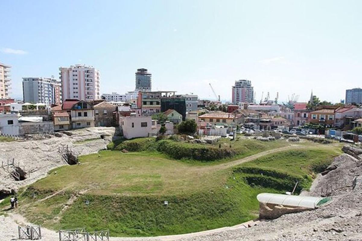 un turó verd amb una ciutat al fons