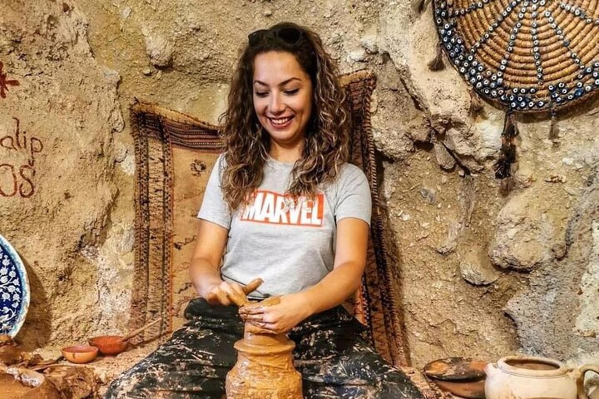 una donna seduta su una sedia che realizza un vaso