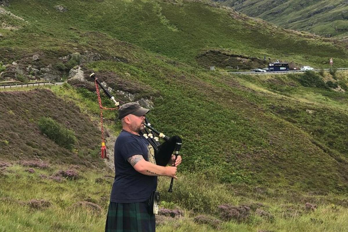 maður stendur úti á akri með myndavél í höndunum