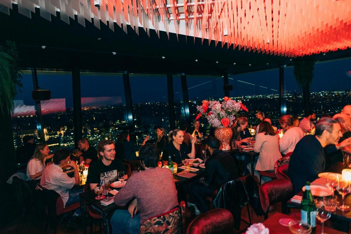 skupina lidí sedících u stolů v restauraci