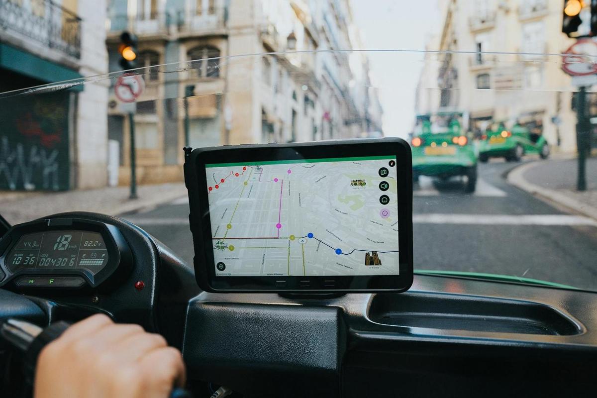 seseorang memandu kereta dengan tablet pada papan pemuka