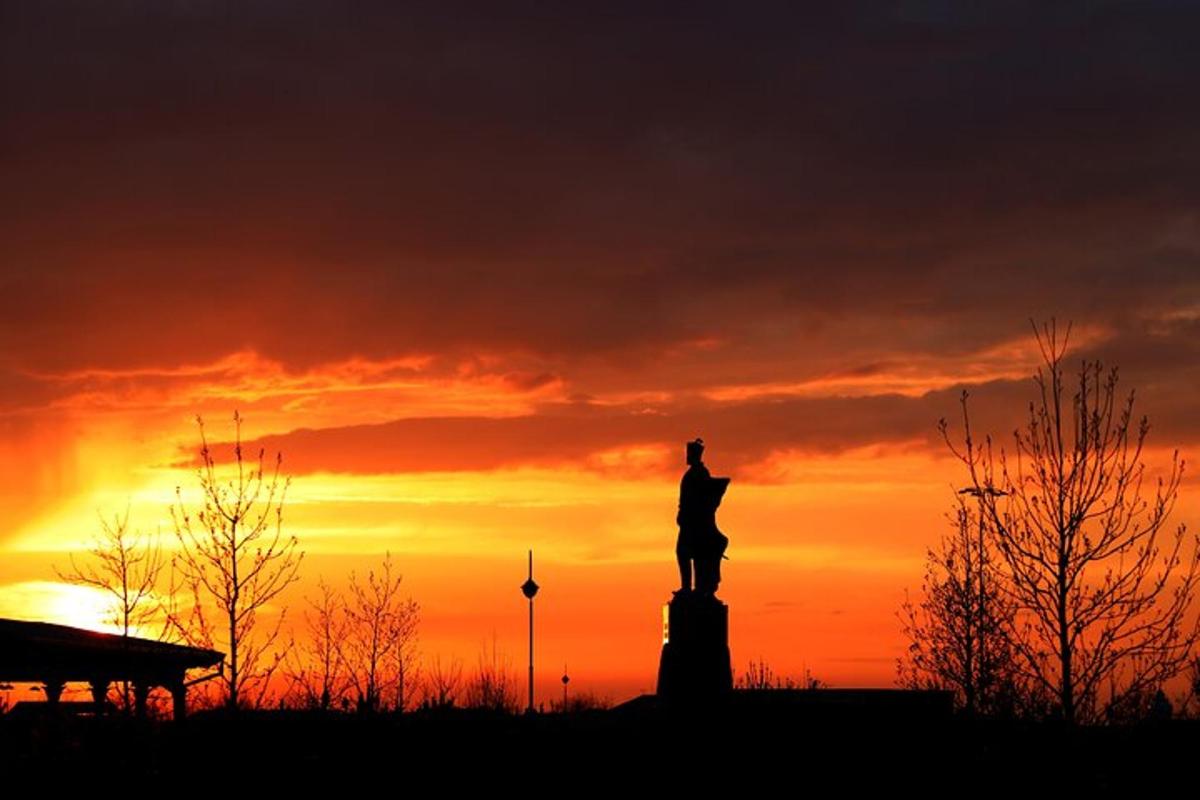 a silhouette of a statue in front of a sunset