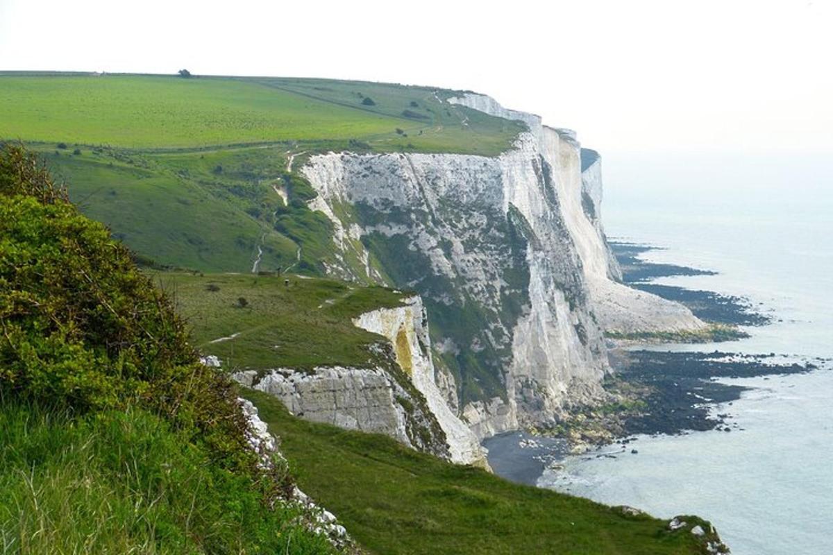 a large white cliff next to the ocean