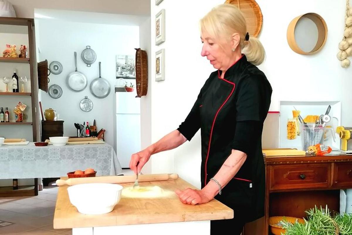 ženska v kuhinji pripravlja hrano na deski za rezanje