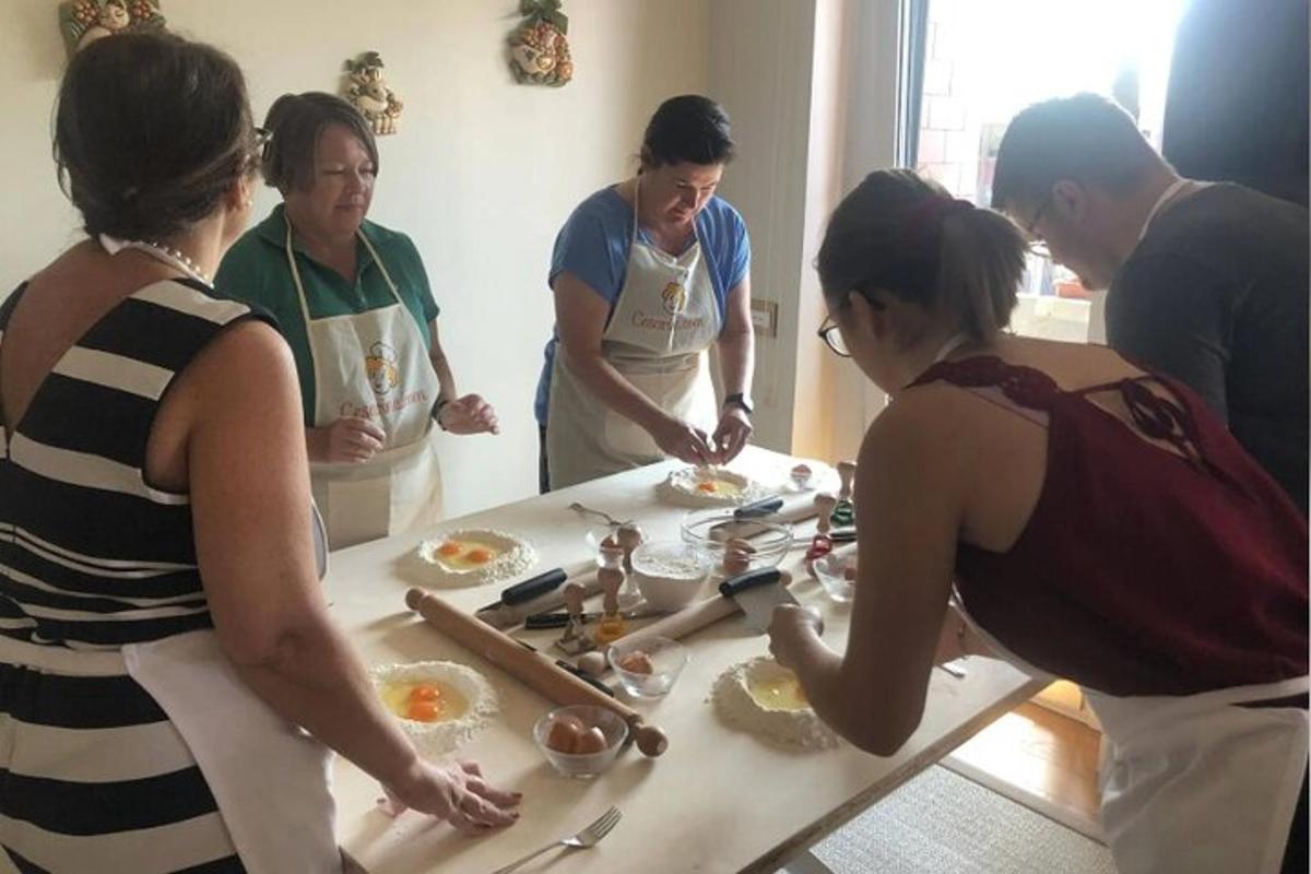 un gruppo di persone in piedi attorno a un tavolo che prepara il cibo