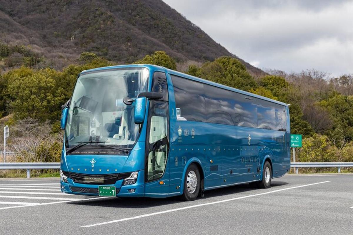 a blue bus is driving down a road