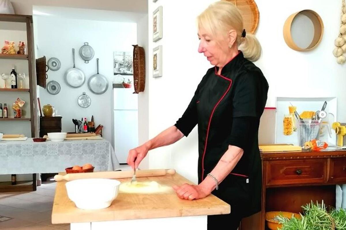 naine köögis lõikelaual toitu valmistamas