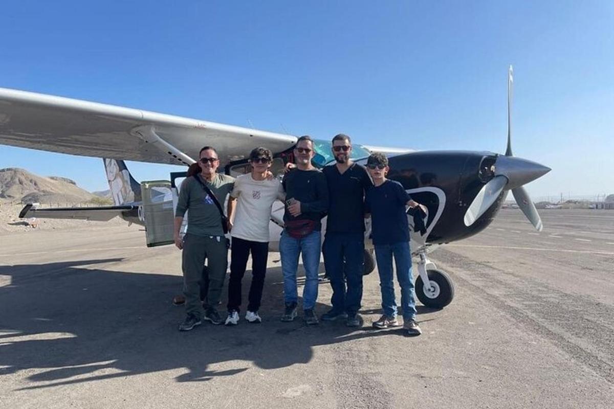 um grupo de pessoas em pé na frente de um avião