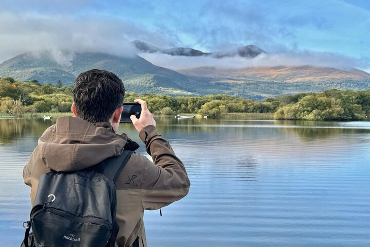 un home fent una foto d'un llac