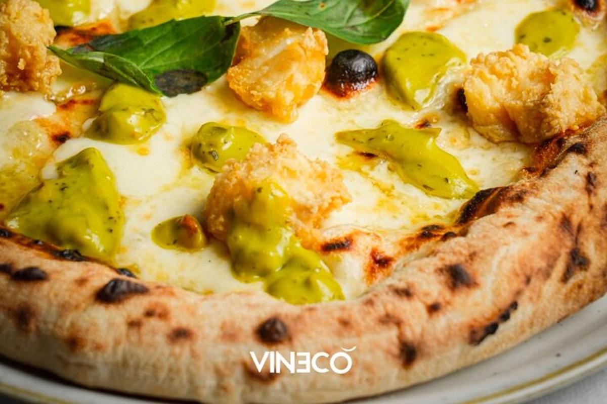 Pizza með grænum paprikum og osti á diski