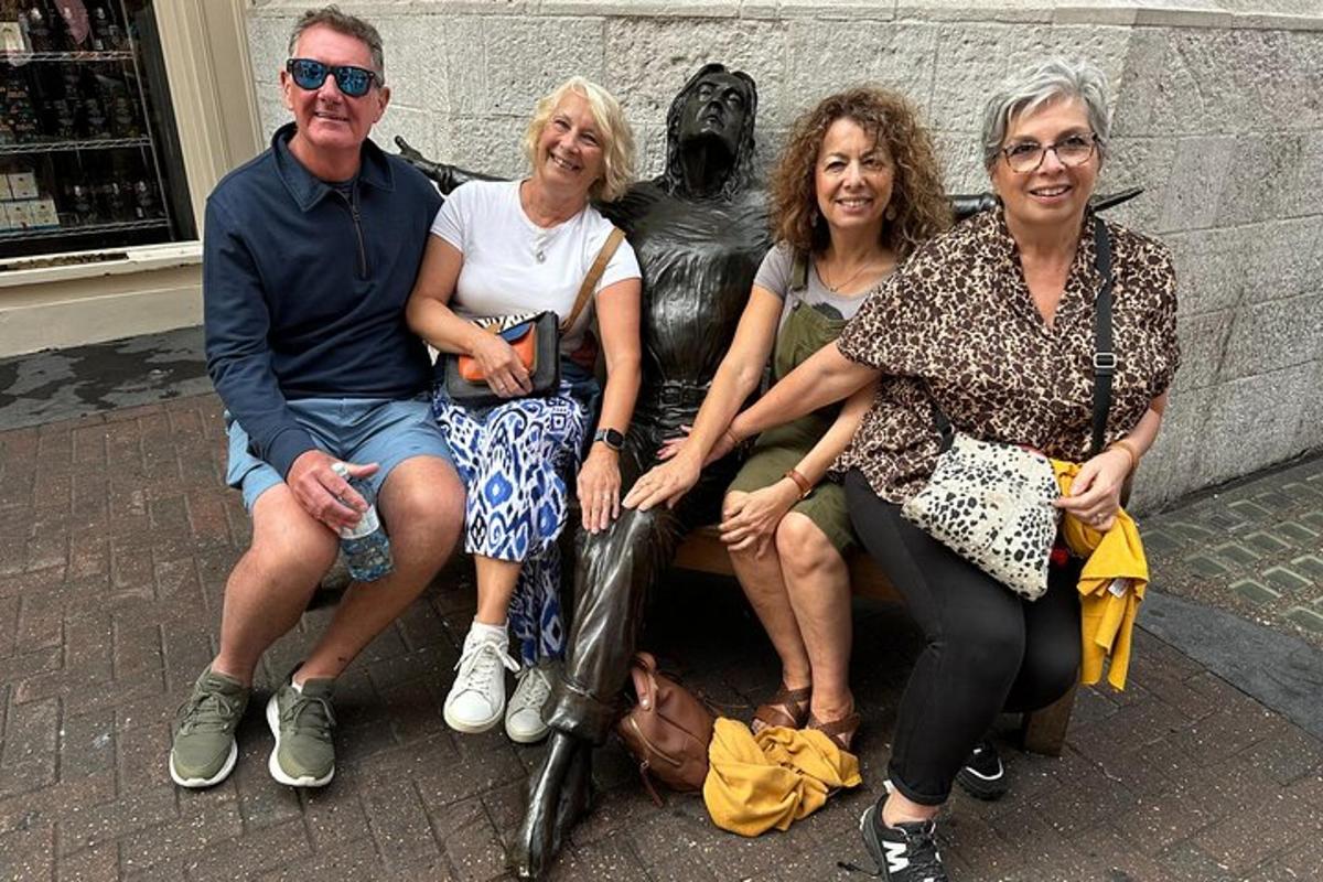 un grup de persones assegudes al costat d'una estàtua