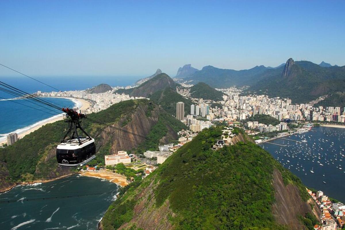 um teleférico voando sobre o oceano próximo a uma cidade