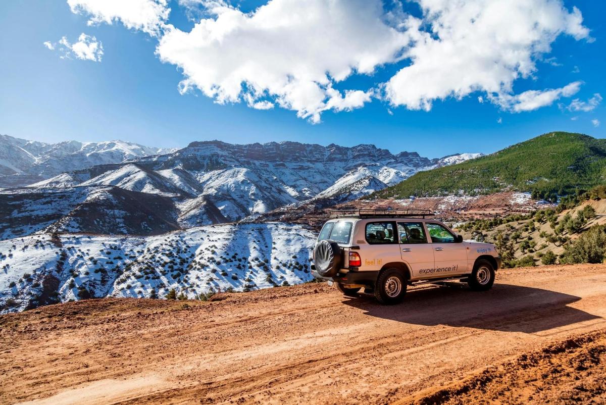 une jeep sur un chemin de terre dans les montagnes