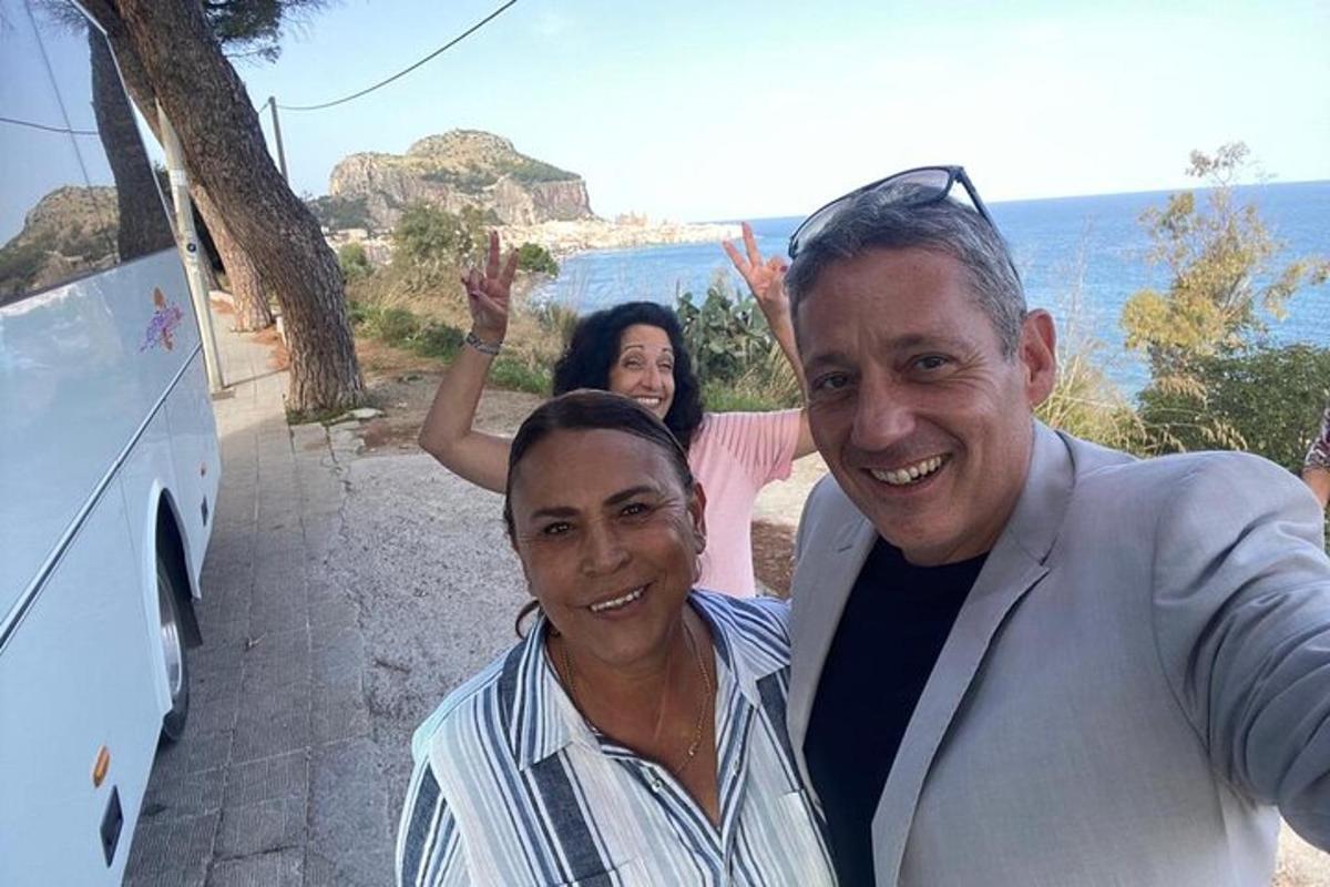 two men and a woman standing next to a bus