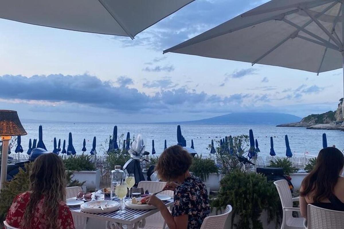 tre donne sedute a un tavolo con vista sull'oceano