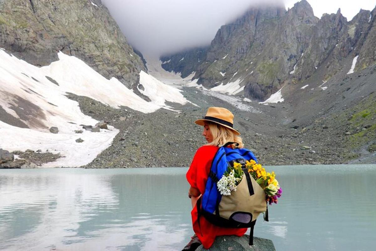 Una mujer parada sobre una roca frente a un lago