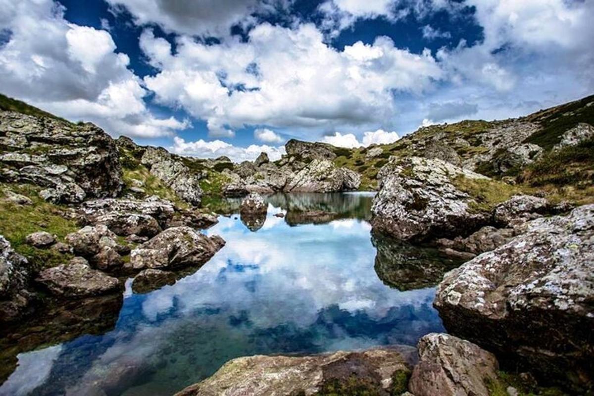 un cuerpo de agua con rocas y nubes en el cielo