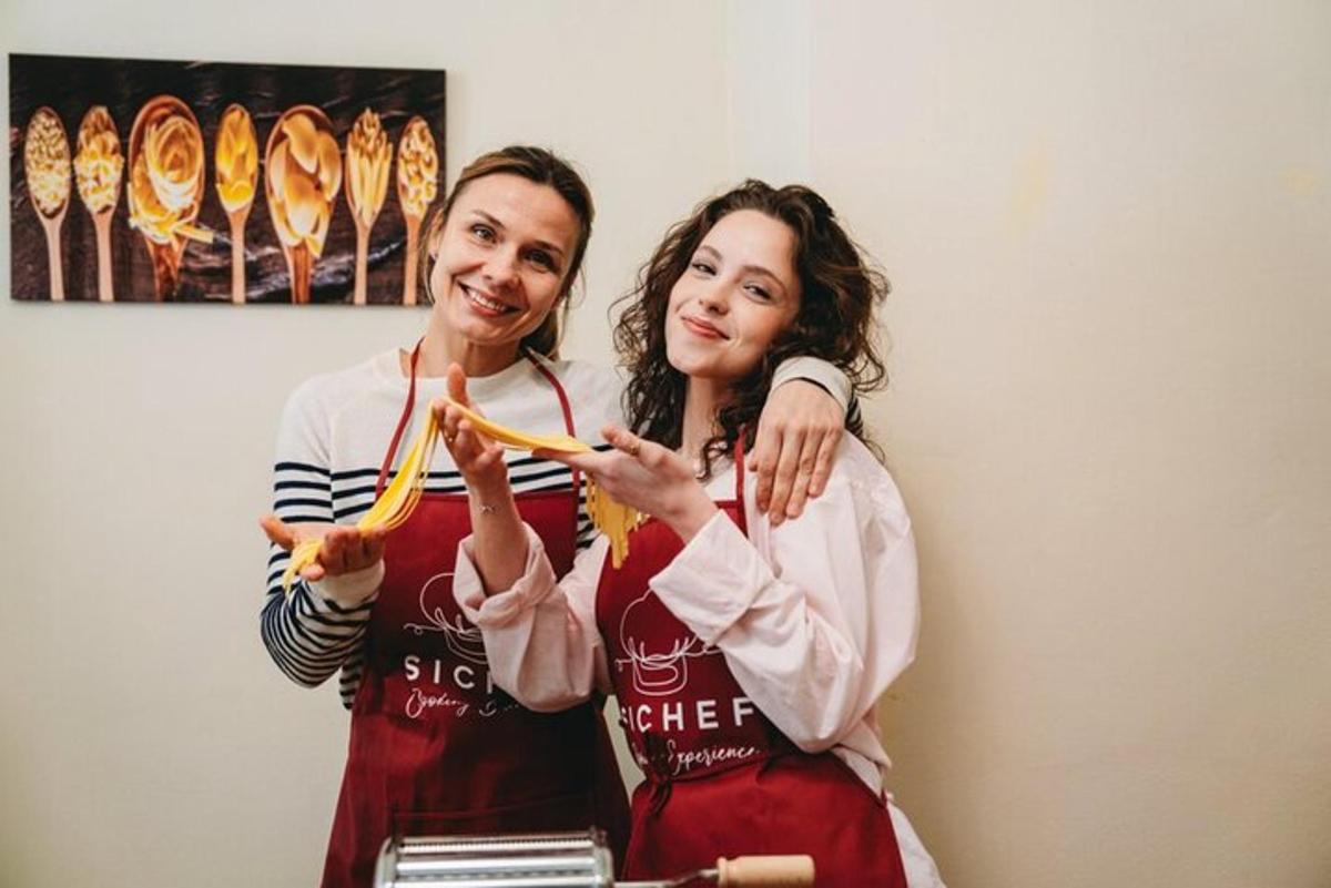 two women standing next to each other holding a banana