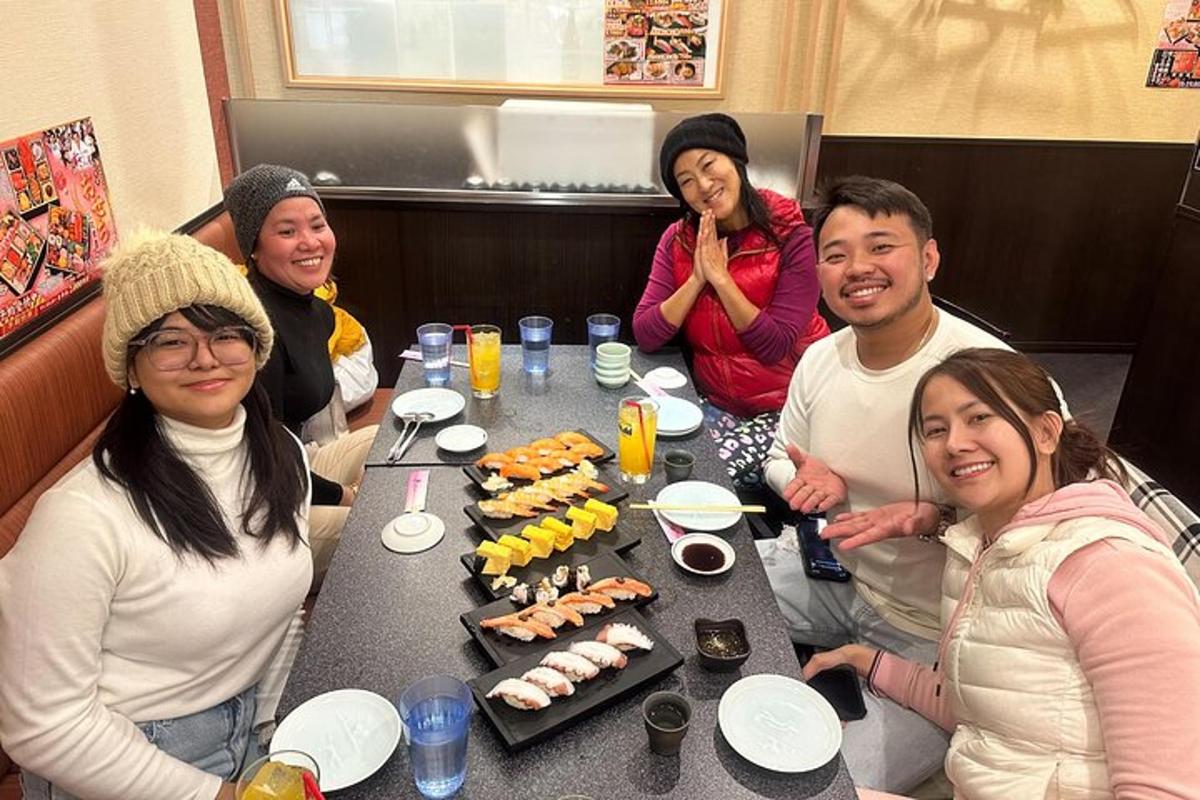 a group of people sitting around a table with sushi