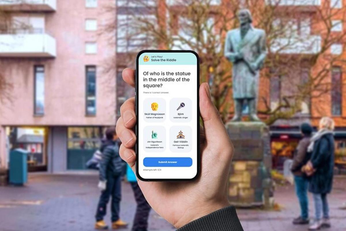 osoba držící mobilní telefon před sochou