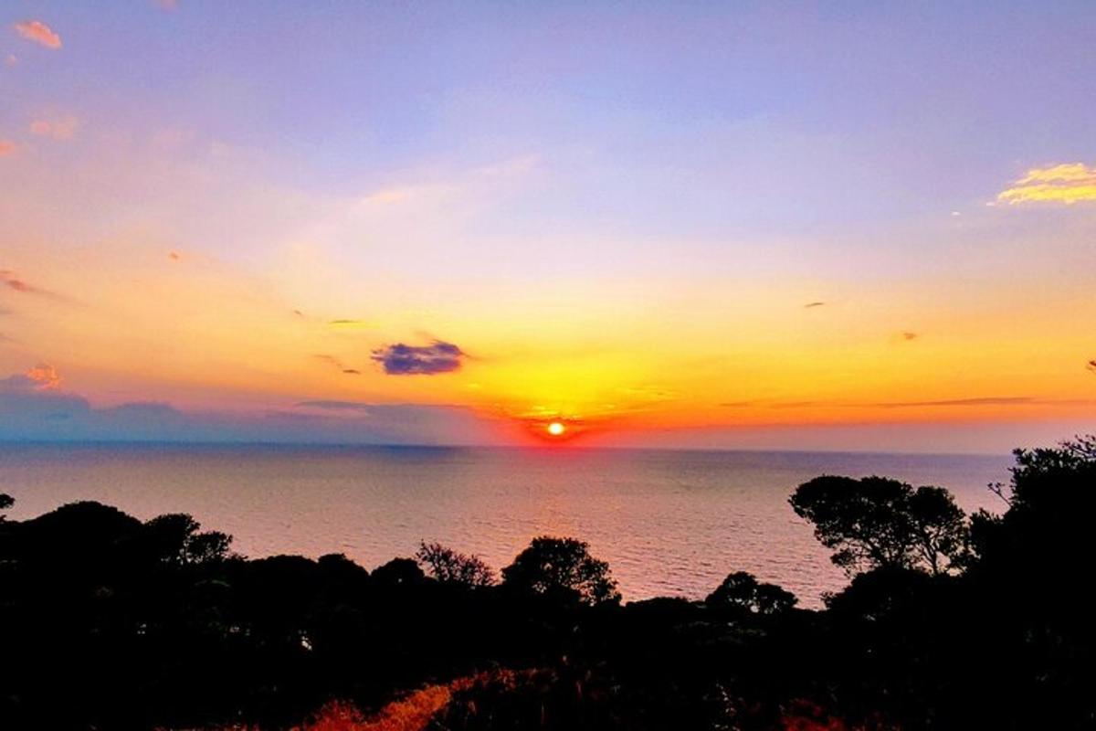 a sunset over the ocean with the sun in the sky