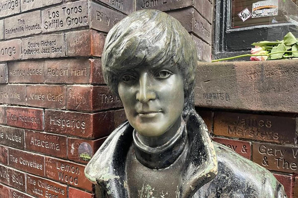 una estàtua d'una noia davant d'una paret de maons