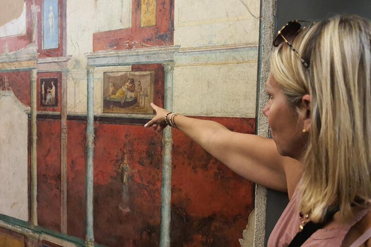a woman pointing at a painting on a wall