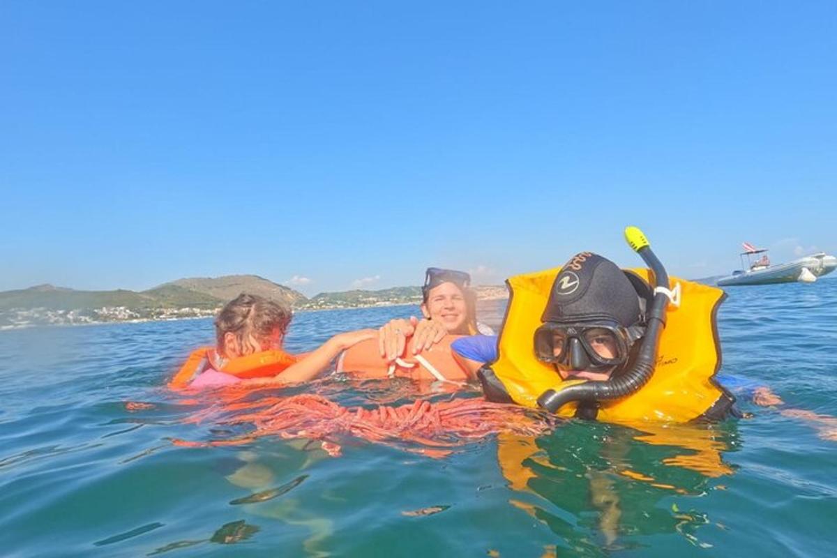 Dos niños están en el agua con un inflable.