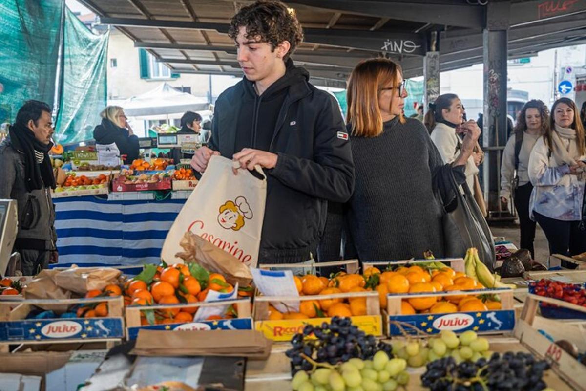 un uomo che tiene una borsa in un mercato della frutta