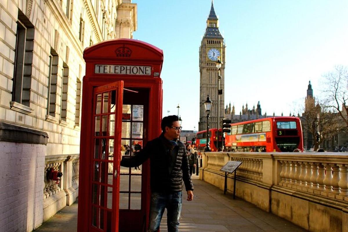 un uomo in piedi accanto a una cabina telefonica di fronte al Big Ben