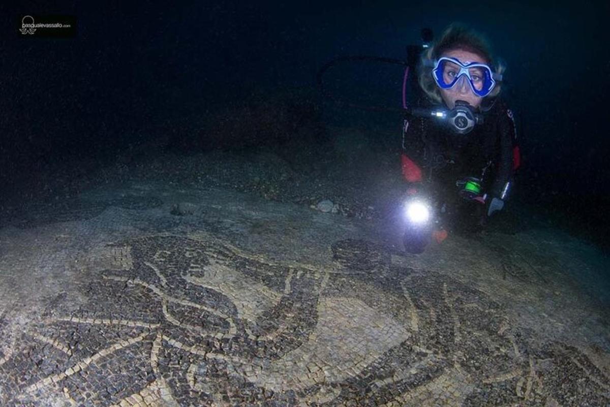 una persona con una macchina fotografica e una luce nell'acqua