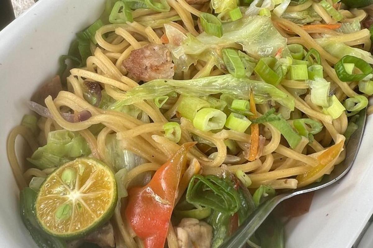 a bowl of pasta and vegetables with a spoon