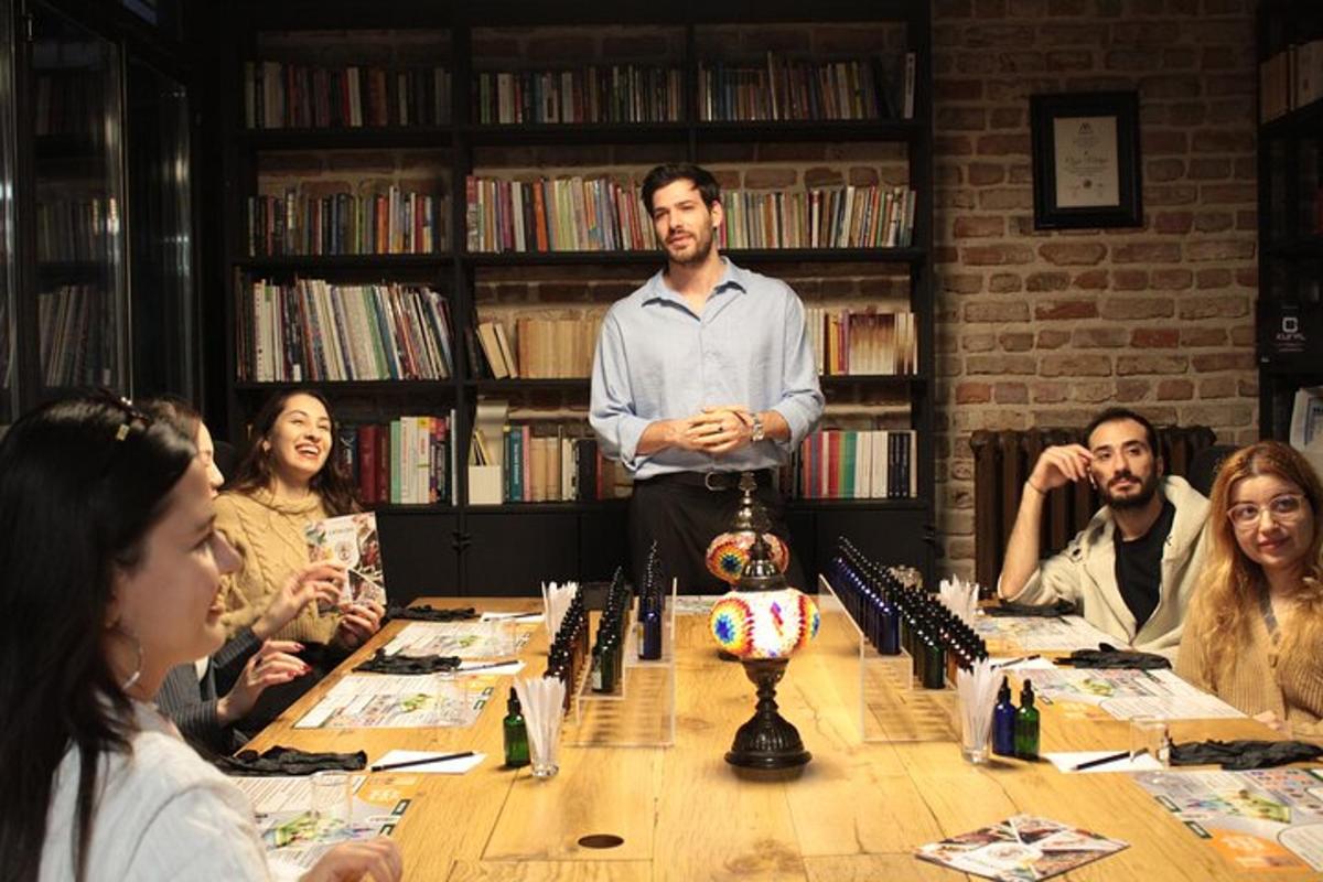 Un hombre de pie frente a un grupo de personas alrededor de una mesa.